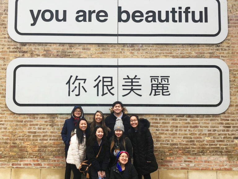 Group photo in front of You are Beautiful sign in 2 languages