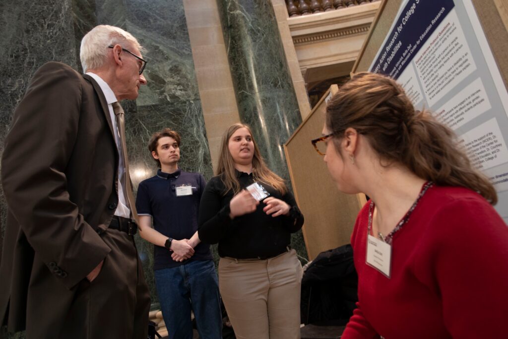 three students presenting on disability advocacy to Governor Tony Evers
